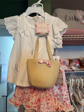 btween White Butterfly Top with Tan Straw Tote and Pink Floral Shorts